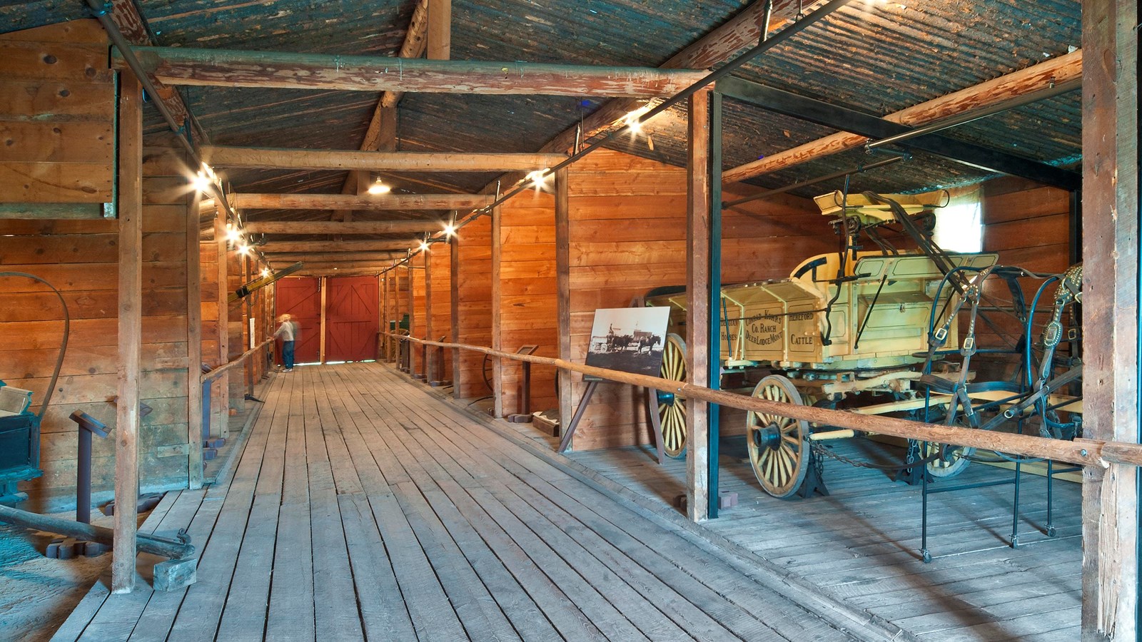 An interior view of the Grant-Kohrs Ranch Thoroughbred barn and the historical equipment on display.