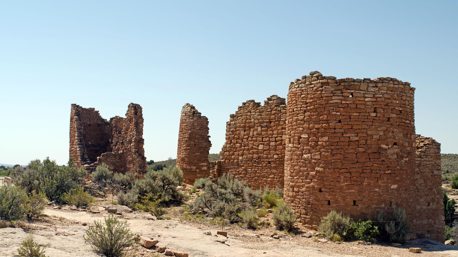 Remains of a large stone structure perched on the canyon rim.
