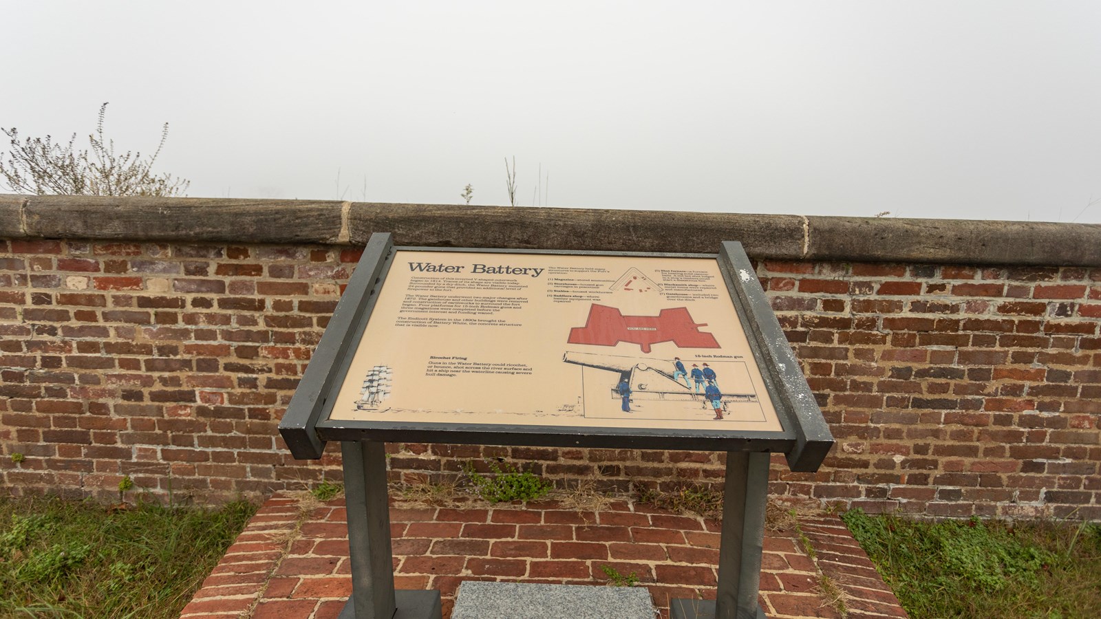 An information panel in front of a short brick-wall, with text, two diagrams, and an illustration.