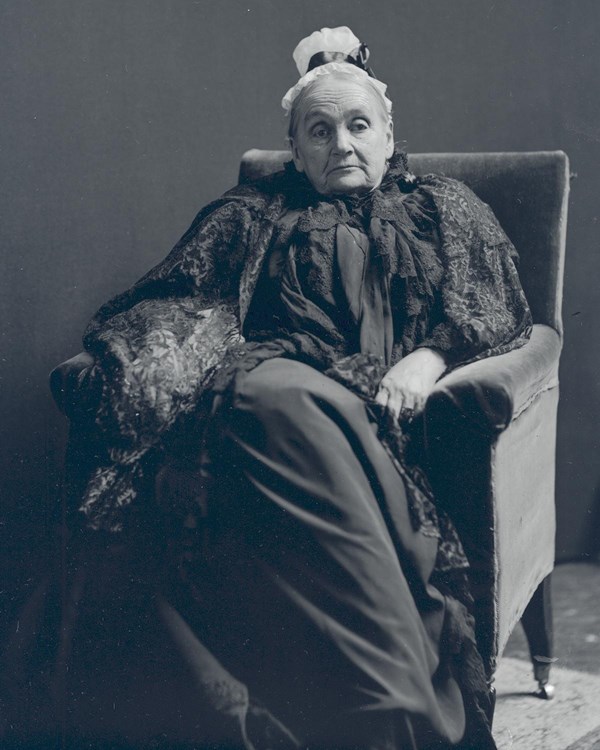 Mary Dorr sits in a chair, wearing black mourning attire.