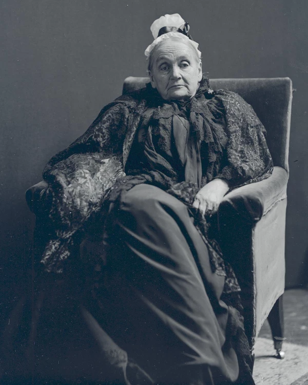 Mary Dorr sits in a chair, wearing black mourning attire.