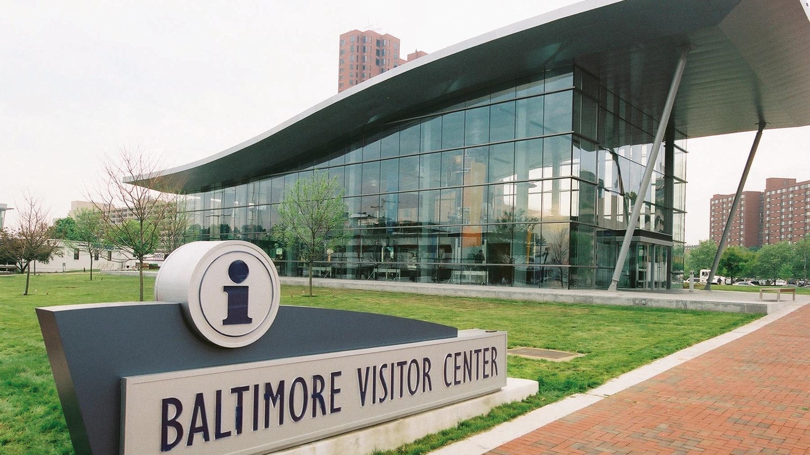 A sign in front of a glass building reads 