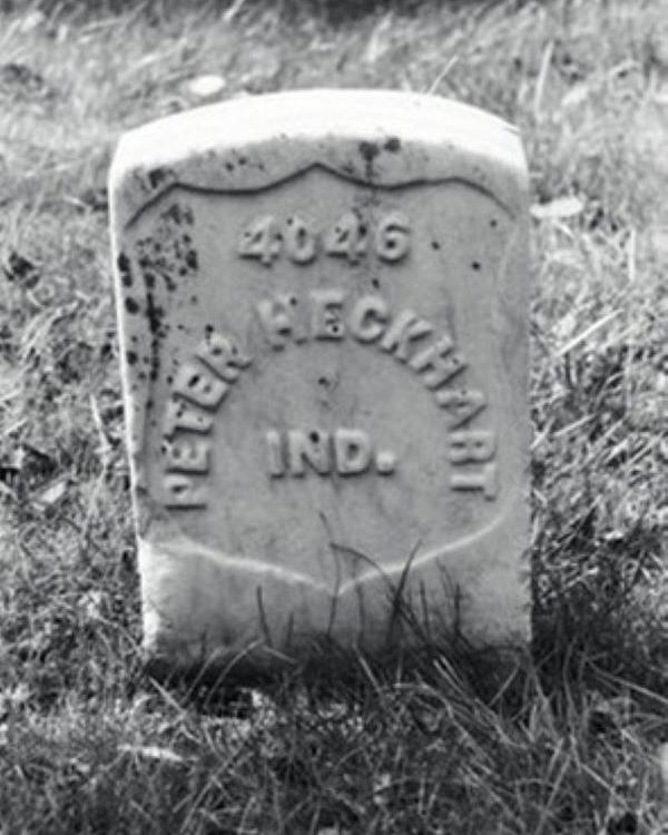 Black and white photo of a headstone that says Peter Heckhart on it. 