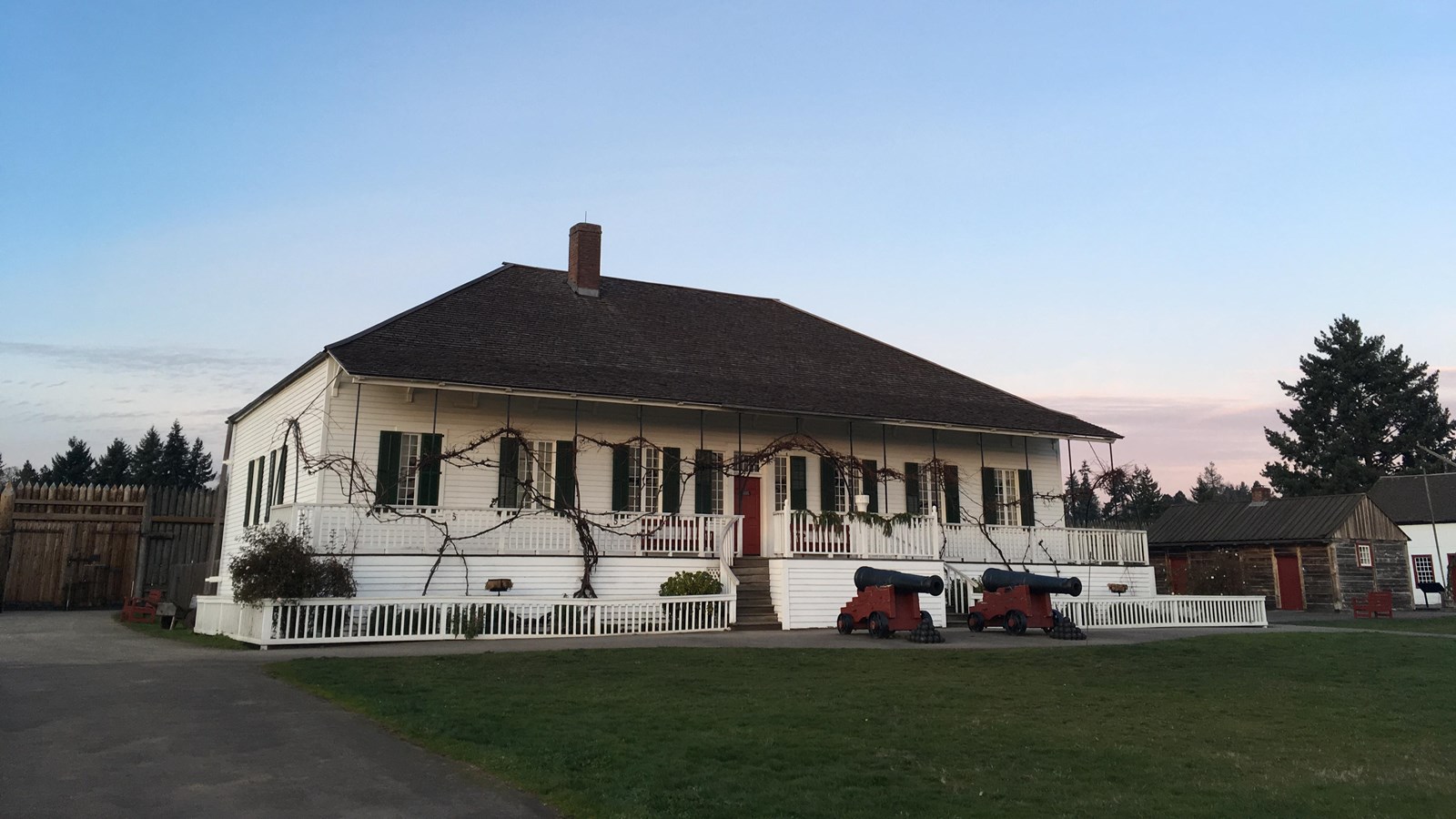 A white two story house inside the fort palisade.