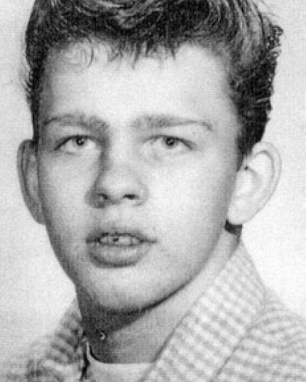 Young boy wearing a checkered shirt and posed for a photo. 