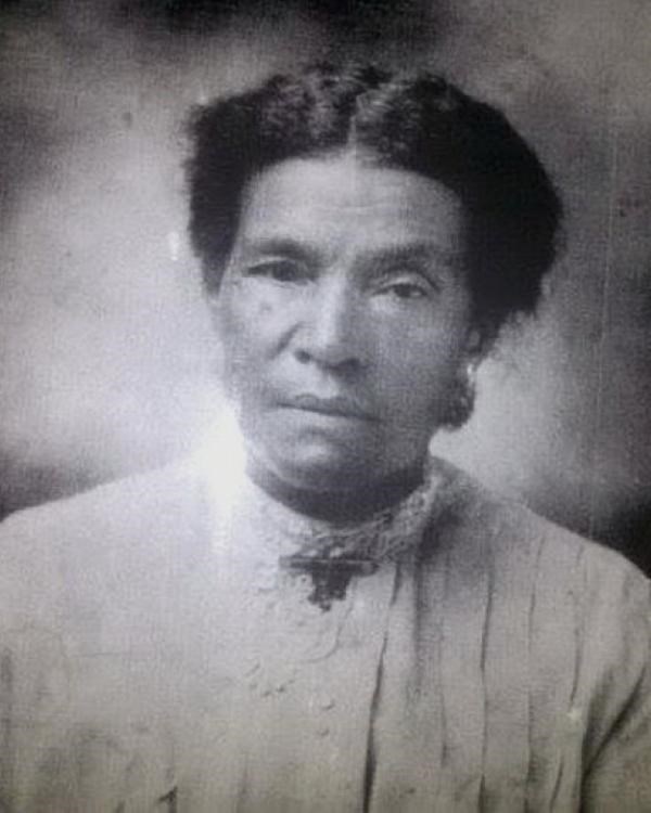 Black and white photo of woman with short black hair and dark eyes.