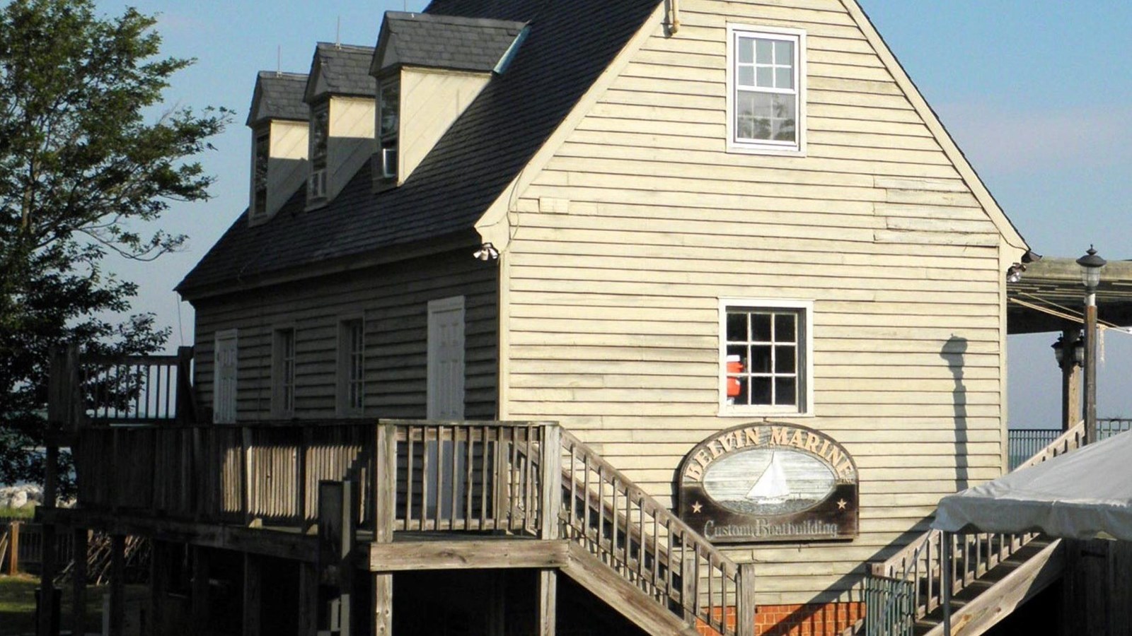 A museum building with white siding and staircases on the side. 