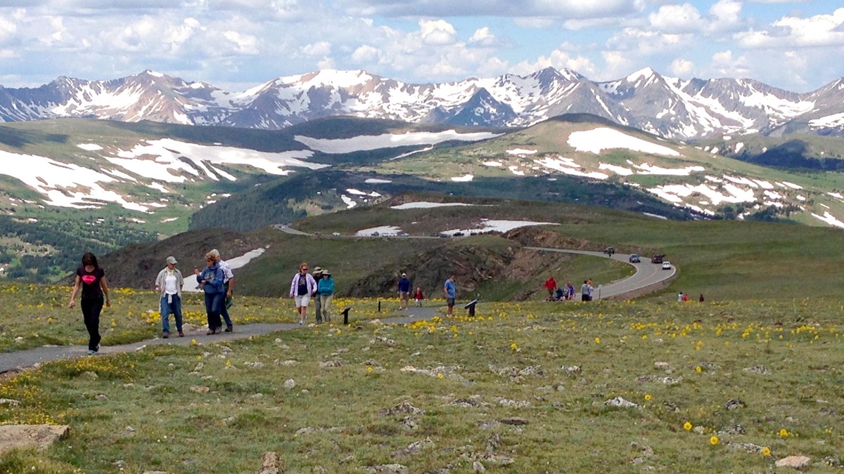 visitors walk along a paved trail on the alpine tundra