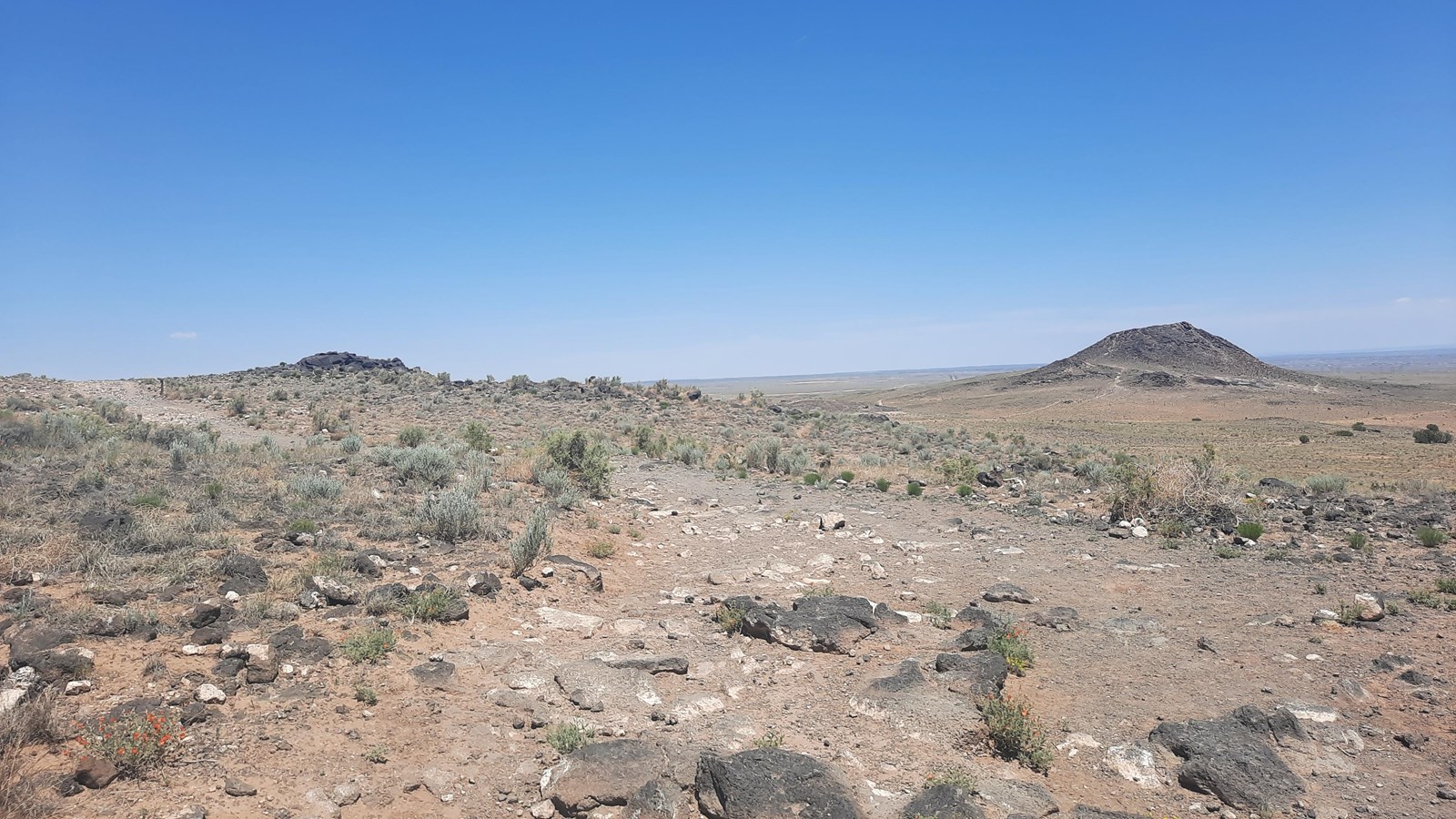 View towards two volcanoes in a desert landscape.