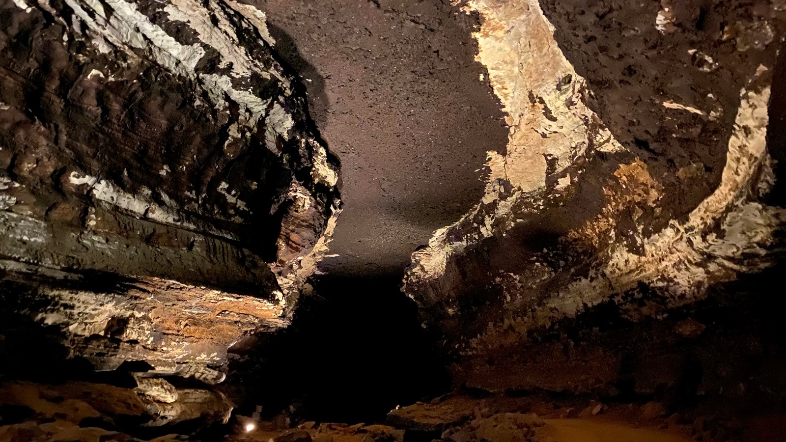 A cave passage with a dark ceiling. 