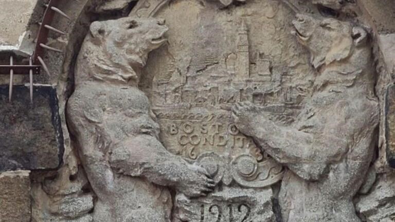 Stone carving of two bears standing up, with 1912 in the middle