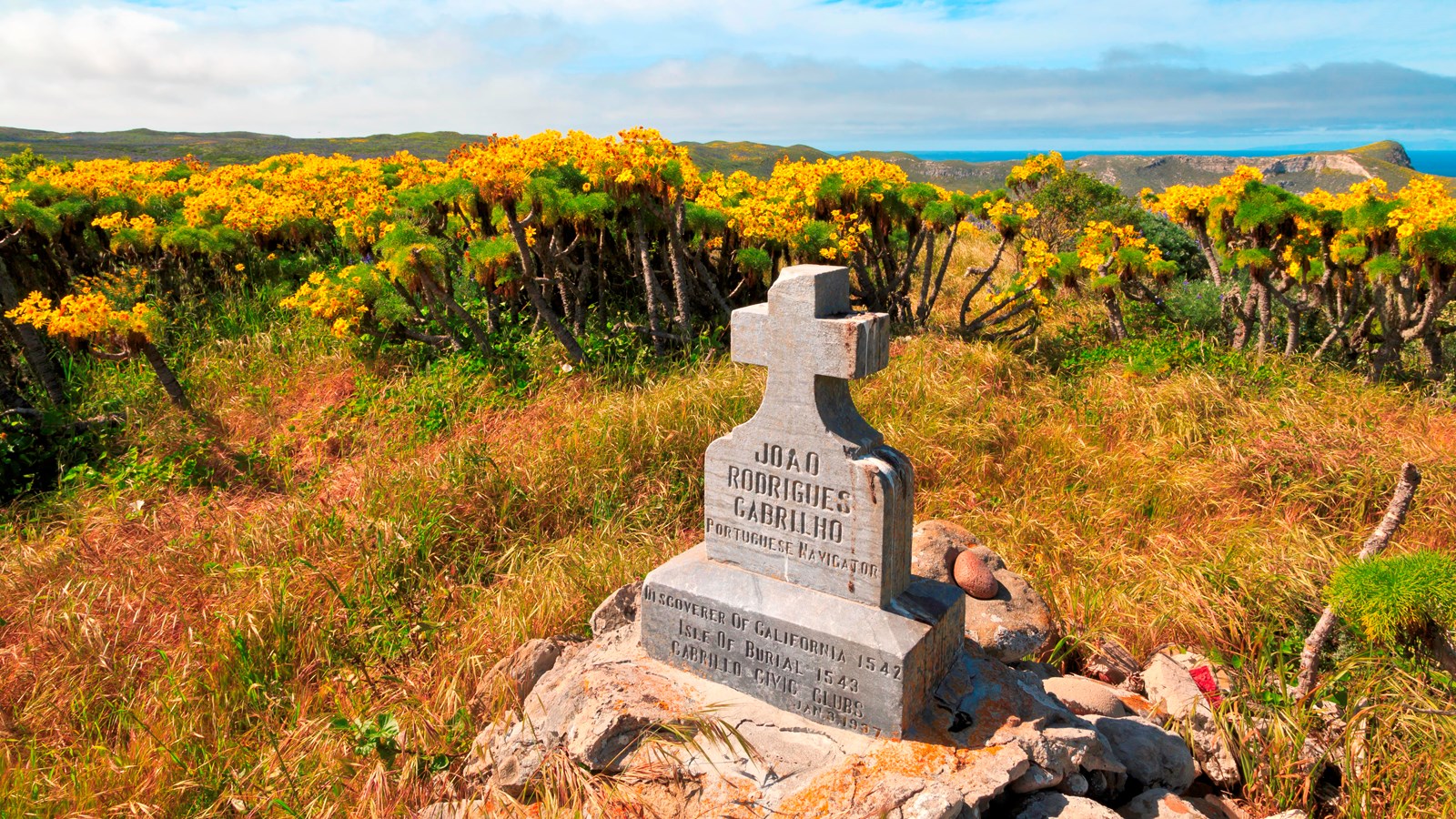 a low monument with a cross overlooking a bay