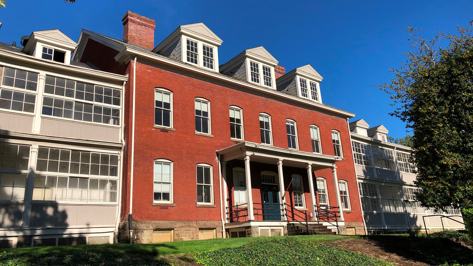 A three-story brick building with enclosed verandas.