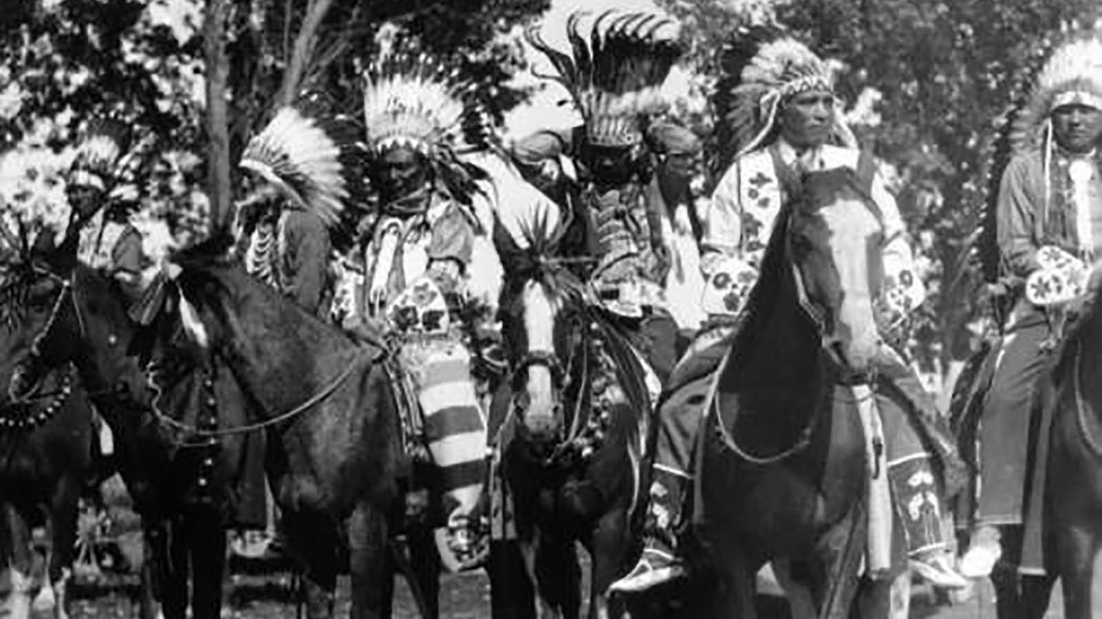 Photograph of six men on horseback, all in formal Shoshone regalia.