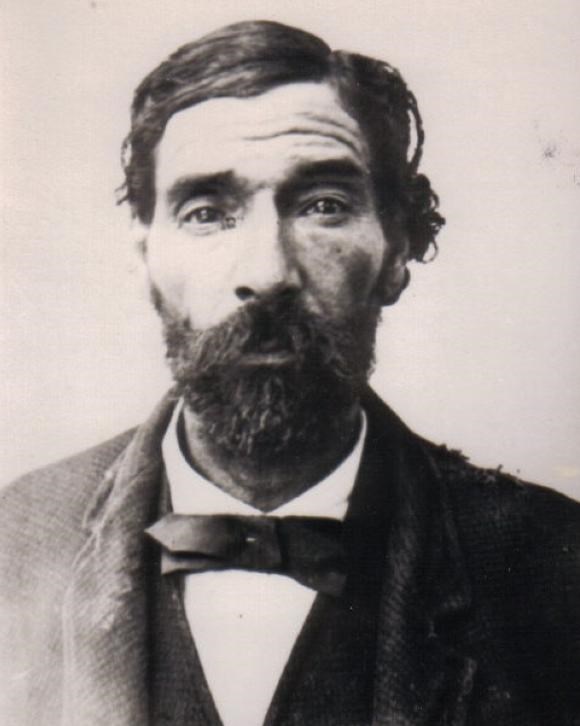 Black and white image of Mulato man, soulful dark brown eyes, mustache and beard, bow tie