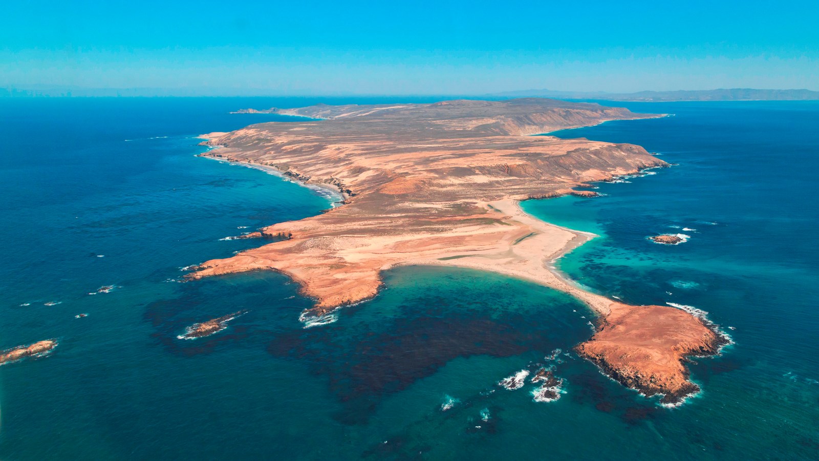 aerial view of low flat island with jagged coast.