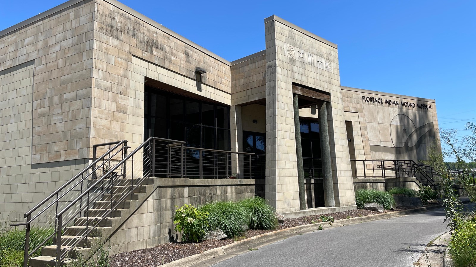 Large cement building with steps on either side of an central entrance.