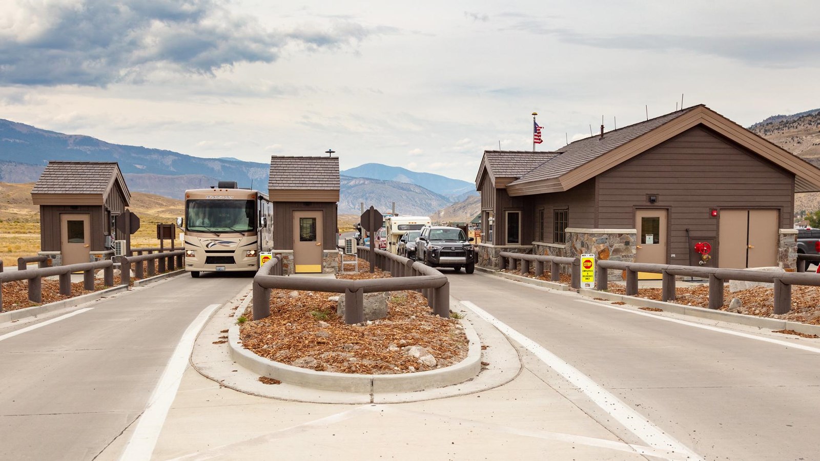 Vehicles drive through a modern entrance station.