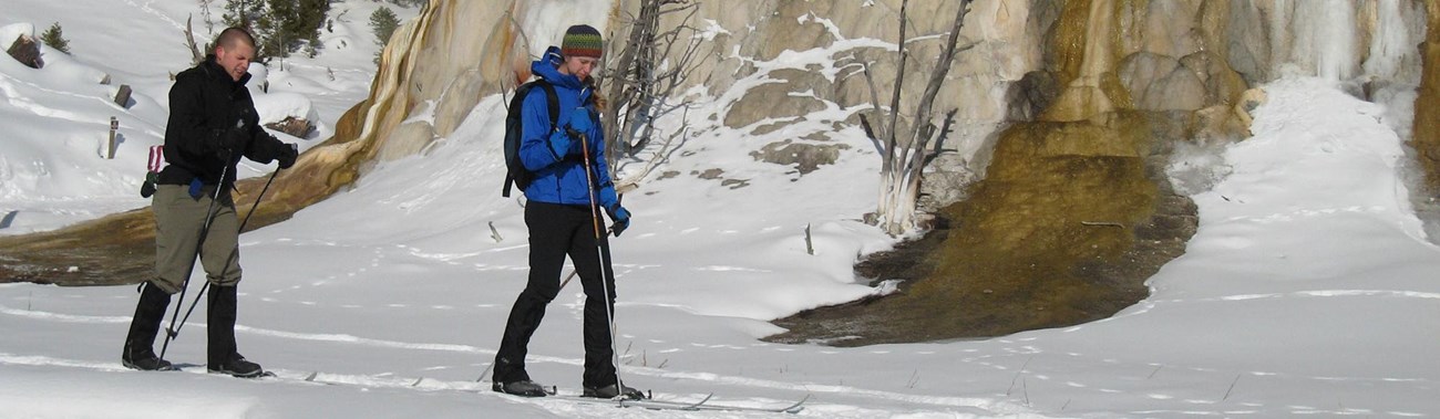 Two skiers glide by Orange Spring Mound along the Upper Terrace Ski Loop.