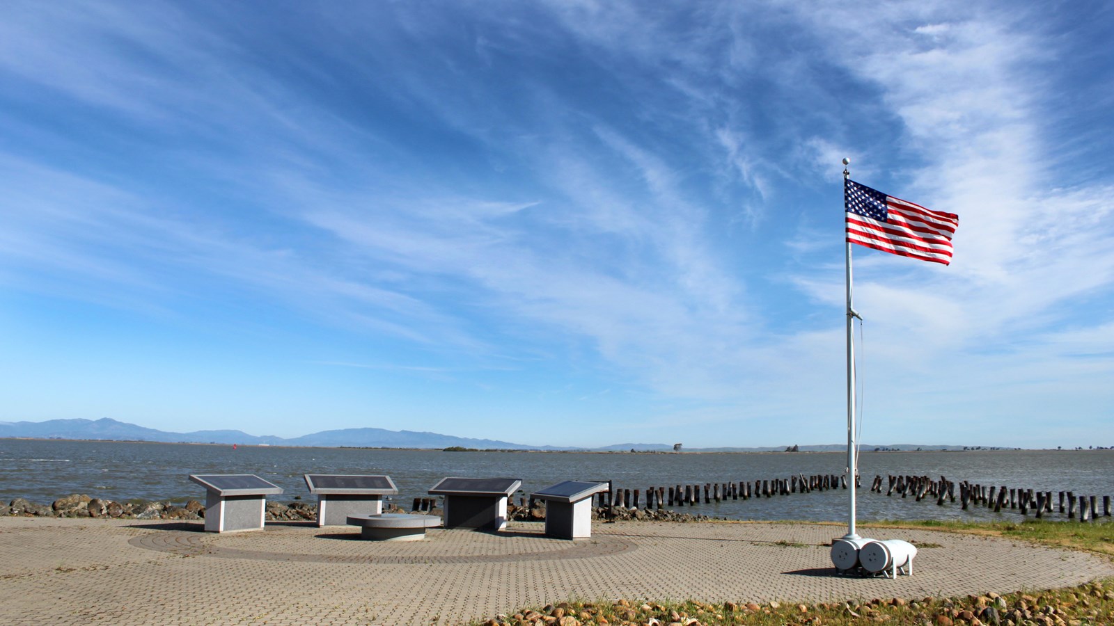 Four memorial stands and a flag can be seen by the waterfront. 