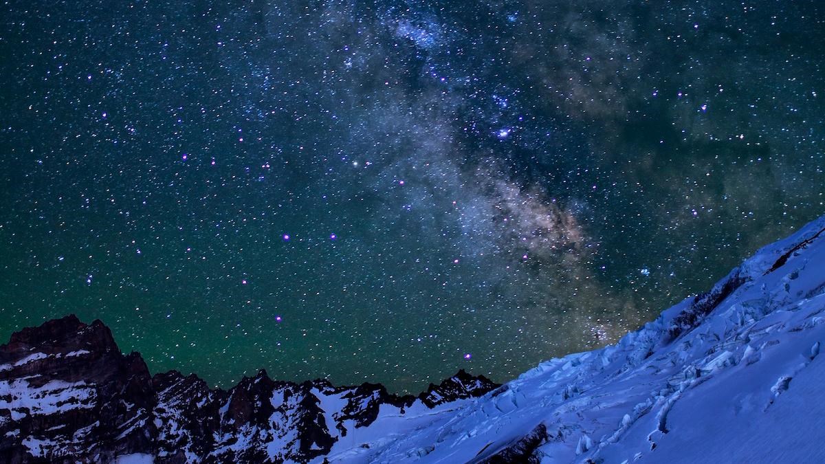  Stars and milky way cover the sky above the glaciated ridges of Mount Rainier. 