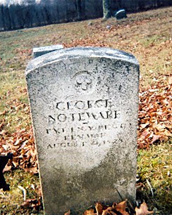 A ragged stone rectangle with the name "George Noteware" carved into it.