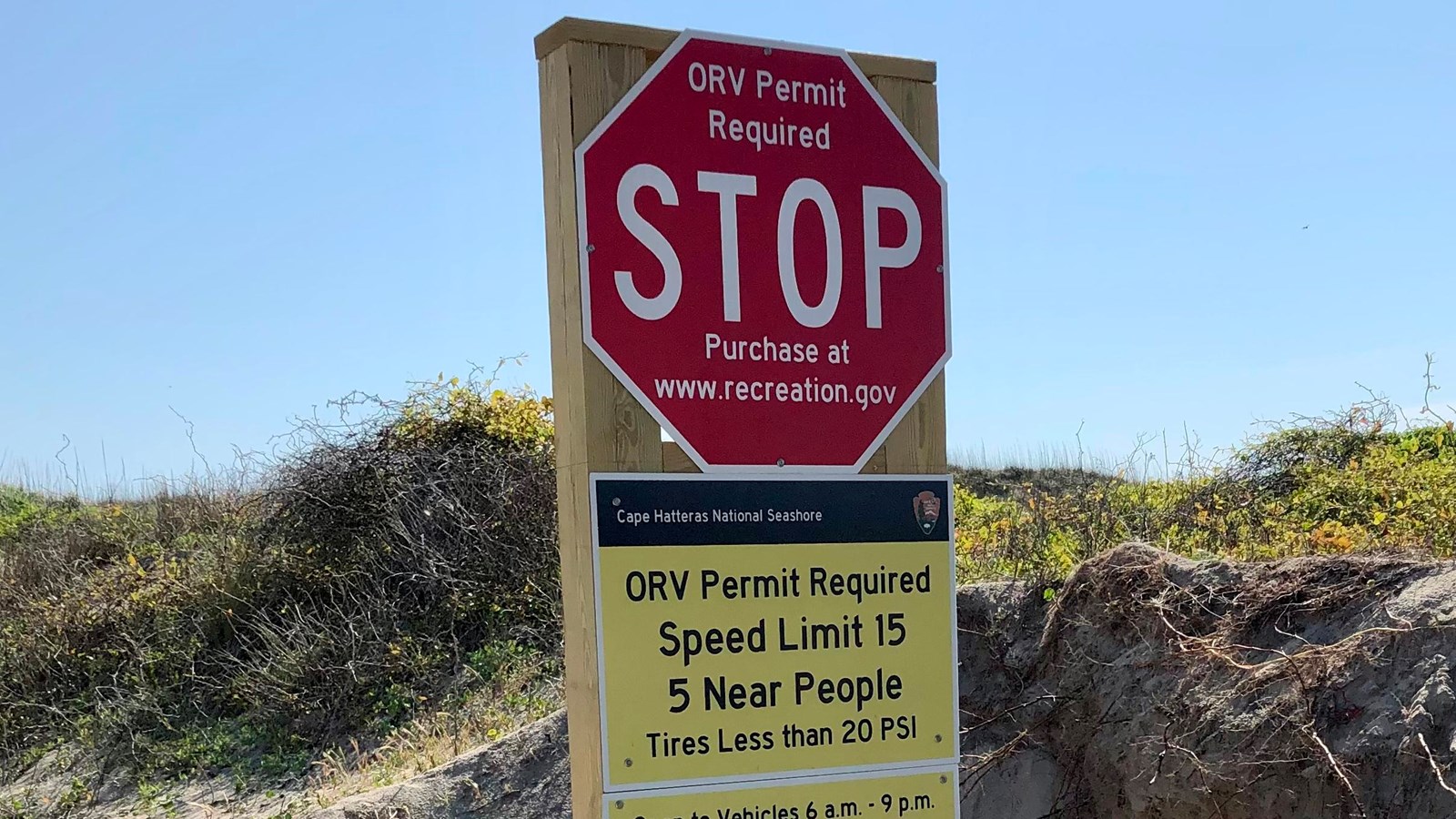 Color photo of stop sign showing info about ORV use at Cape Hatteras National Seashore.
