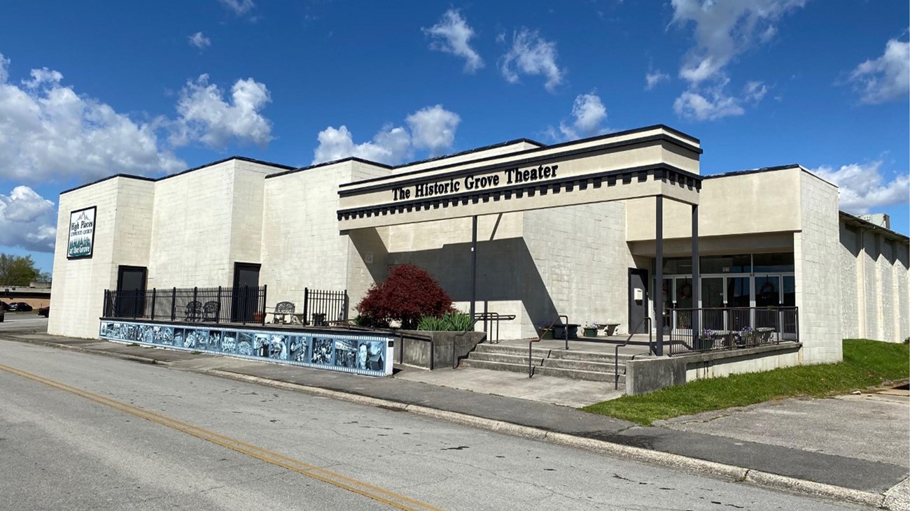 A large, white, blocky building with “The Historic Grove Theater” on the marquee.