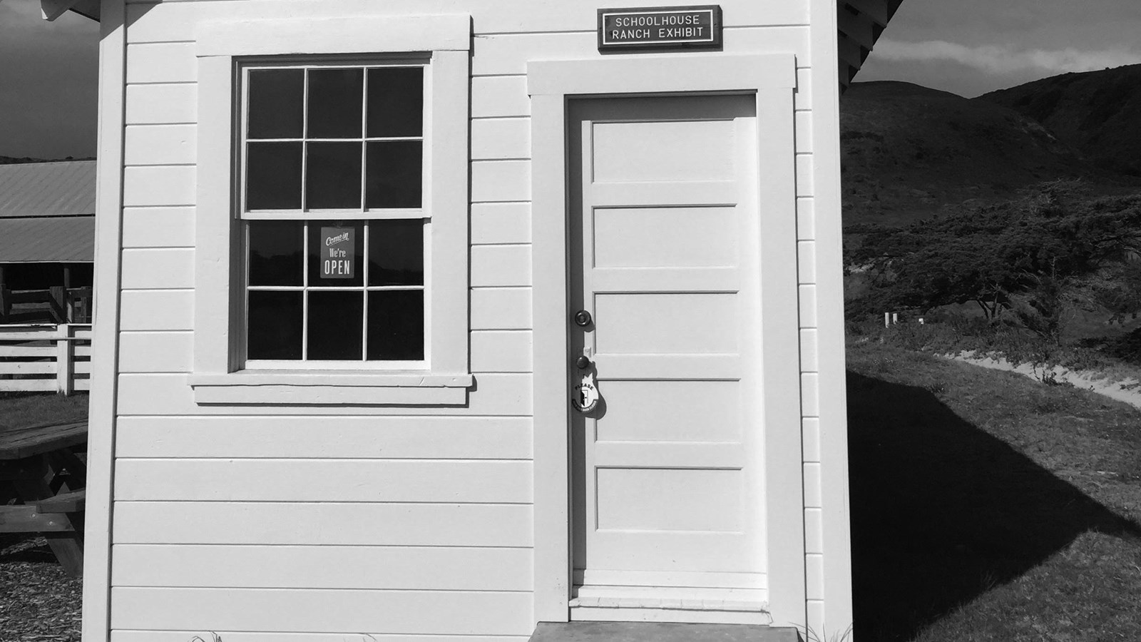Small white house with one window and door.