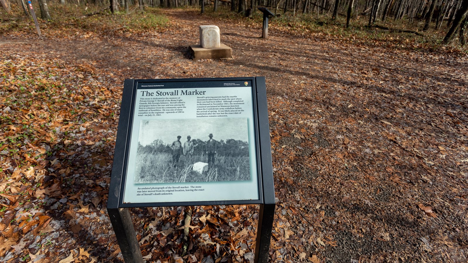 A photo of three men standing over a piece of white block is displayed on the information panel.