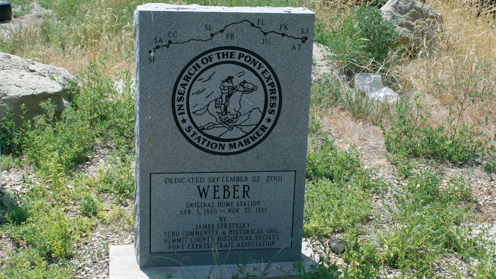A stone marker in a grassy area.