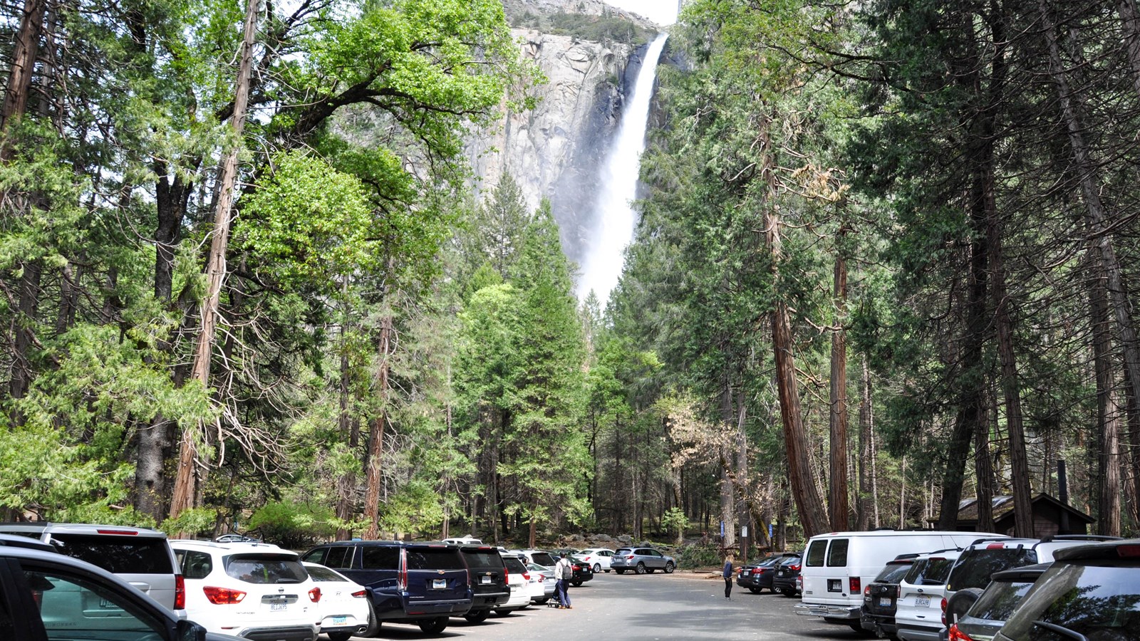 Cars parked in the lot with the waterfall visible in the background