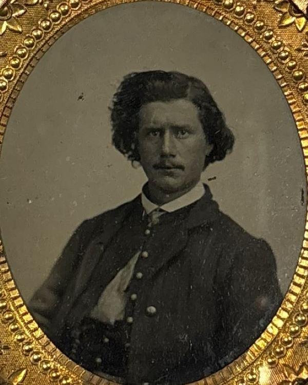 Young man with combed hair wearing a Union uniform and posing for his photo.