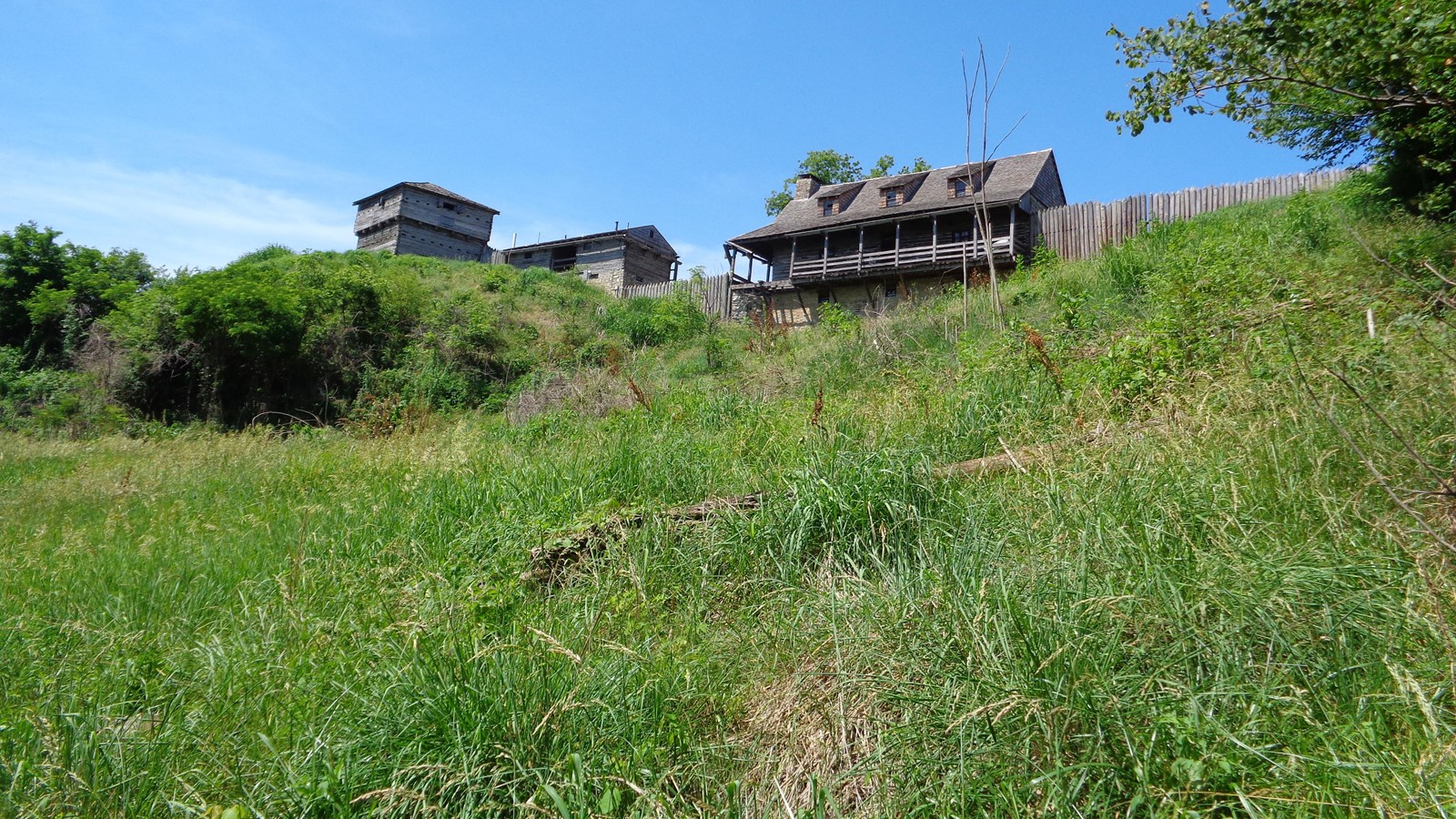 Large wooden buildings on top of a grassy hill
