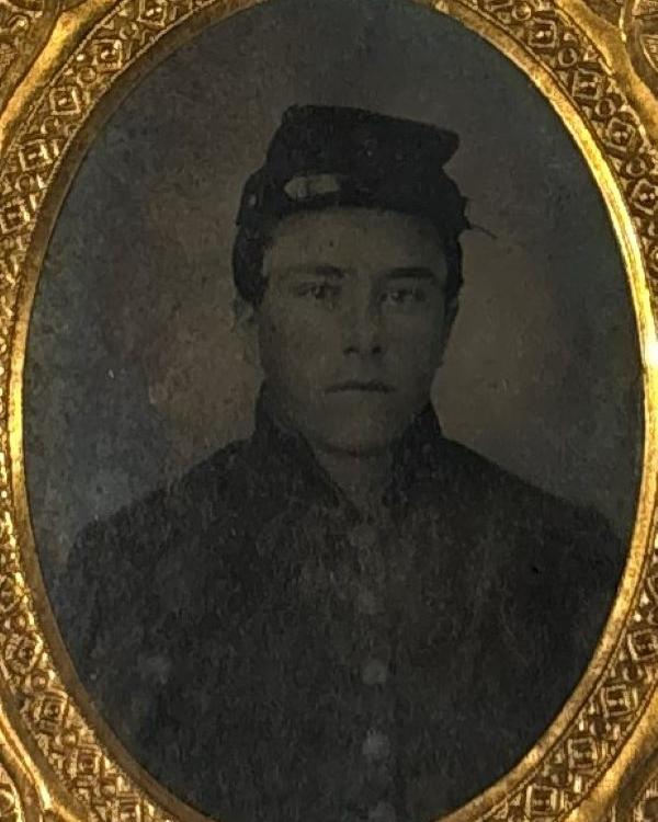 Young man wearing a Union uniform and Kepi posing for his photo without smiling. 
