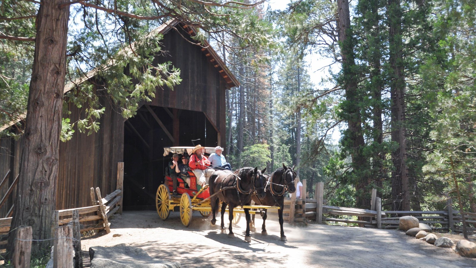 Horse drawn stage coming through covered bridge with passengers