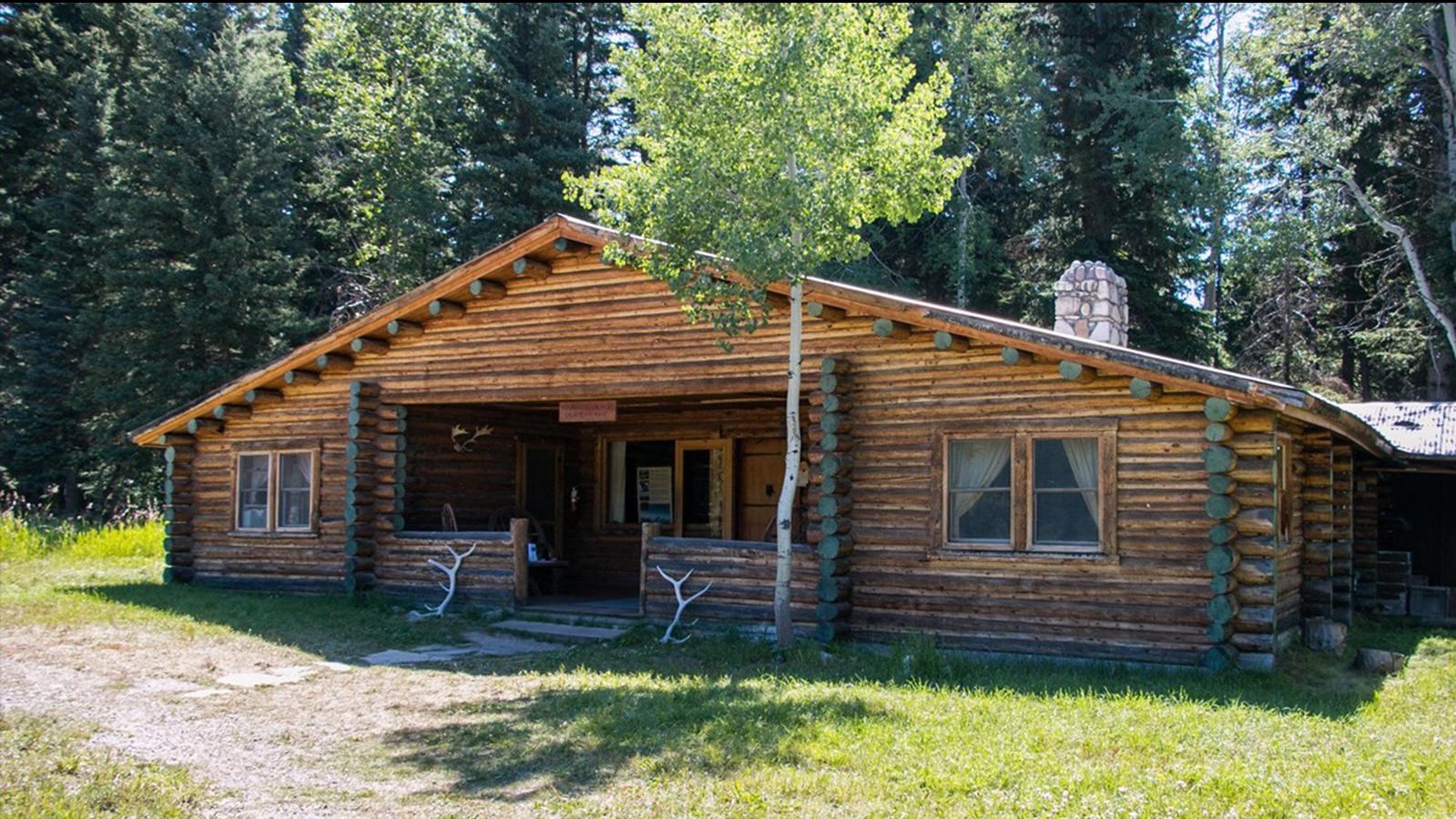 A historic log cabin in a forest 