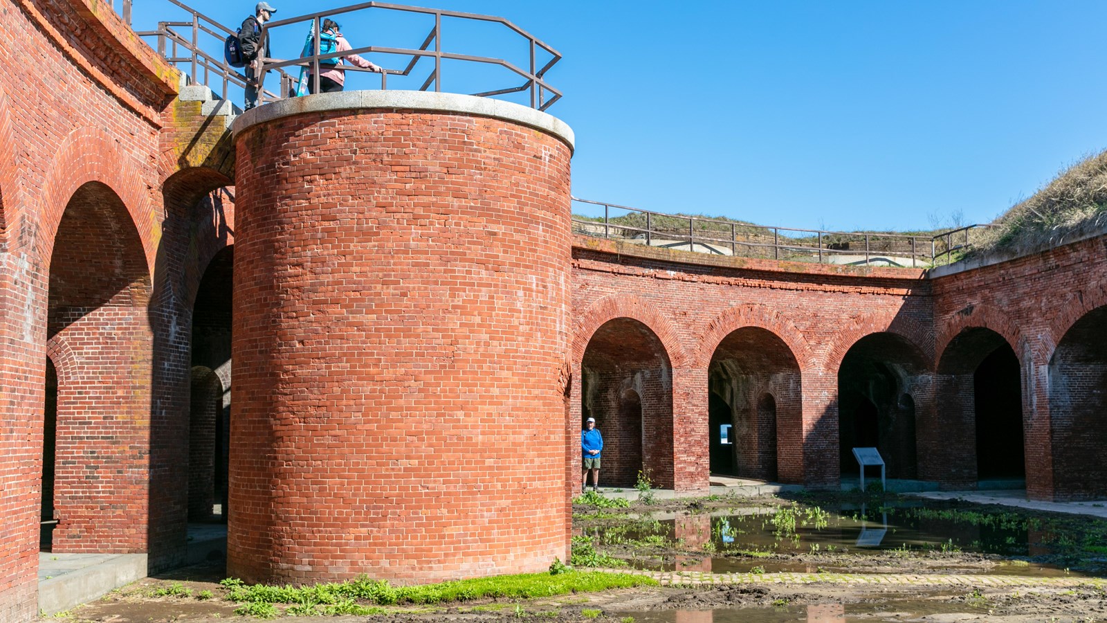 A large brick tower stands in the middle of a flooded fort.