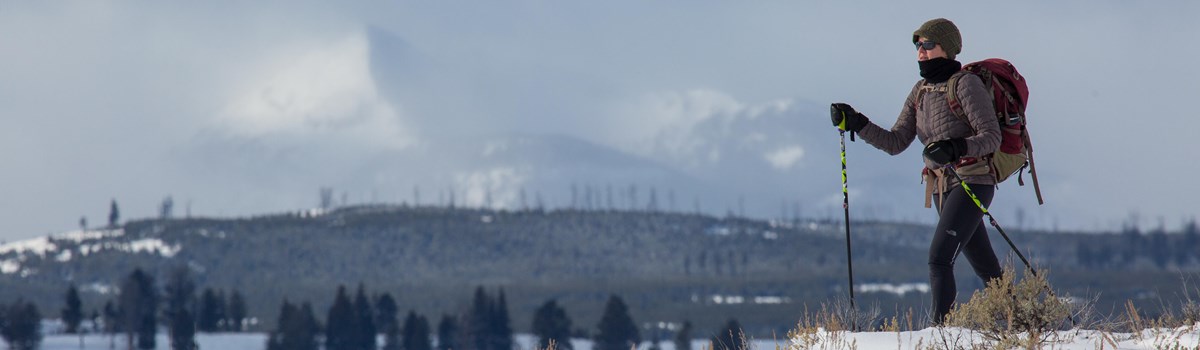 A solitary skier glides through fresh snow on Blacktail Plateau Ski Trail.