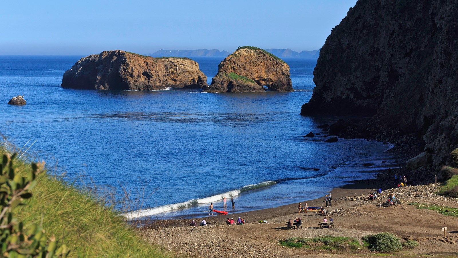 off shore rock with steep cliffs and sea caves.