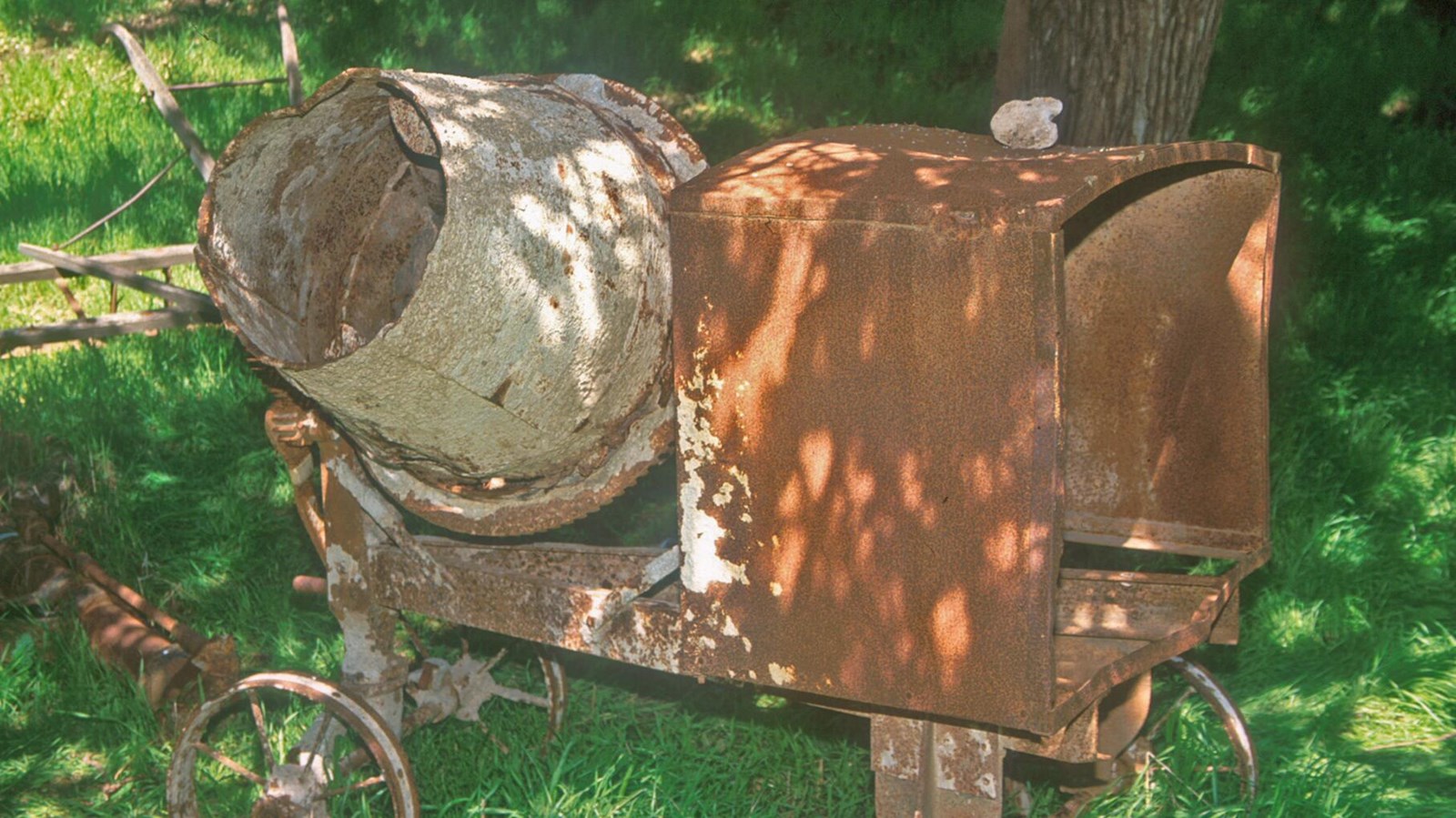 This portable cement mixer is on a wheeled cart that holds the engine box and barrel.