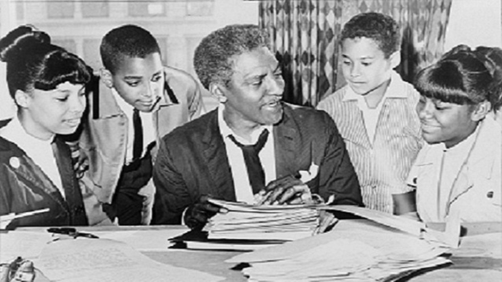 Historic photo of Bayard Rustin talking to children