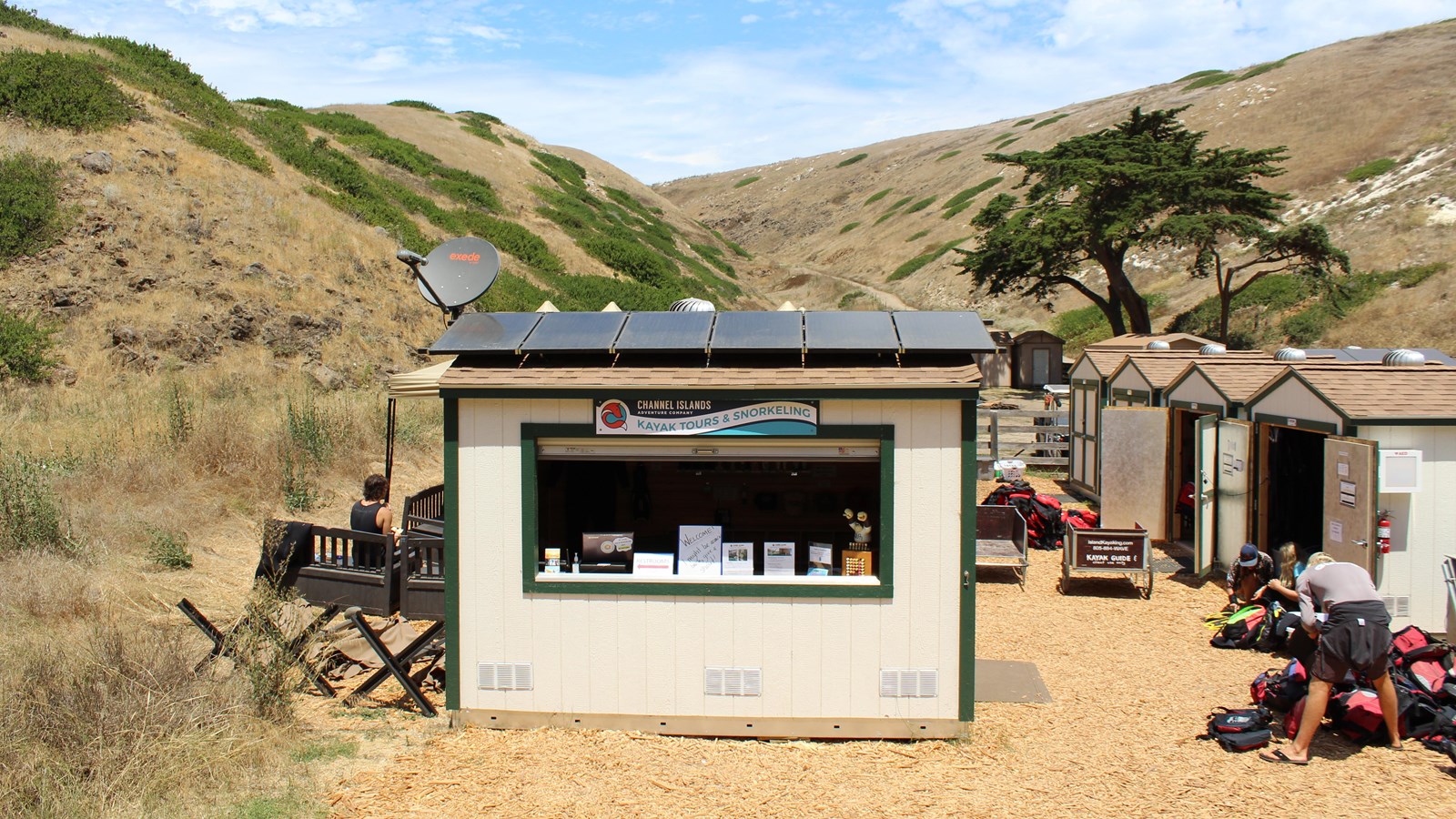 Small white building with open front serving as store.