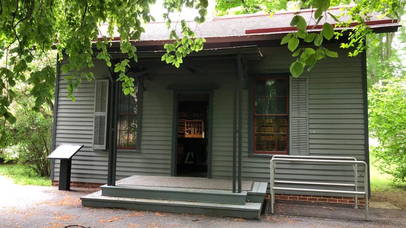 a small gray building with two small steps to the front door