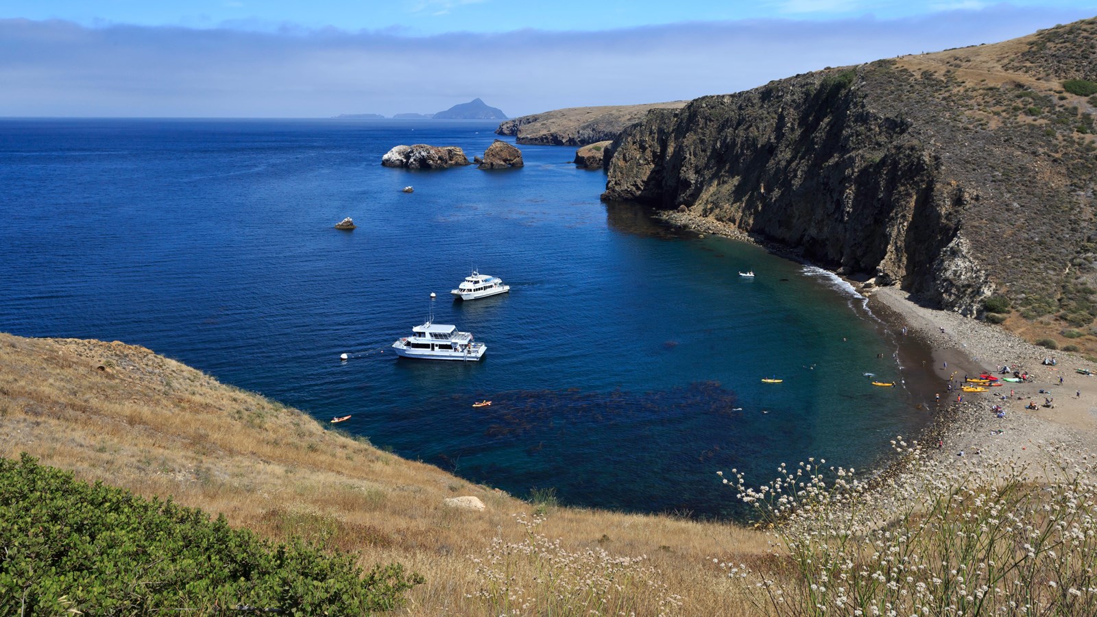 Scorpion Anchorage is a small harbor with a rocky beach. A small pier sits in the harbor.