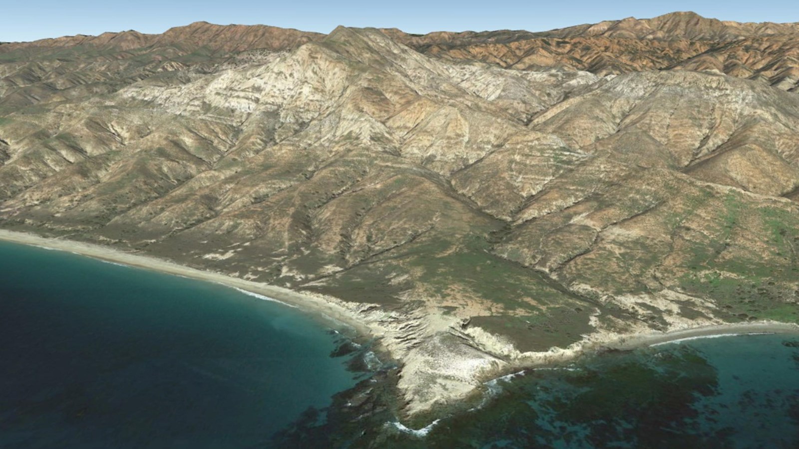 a tall white mountain that rises up from a rocky island coast