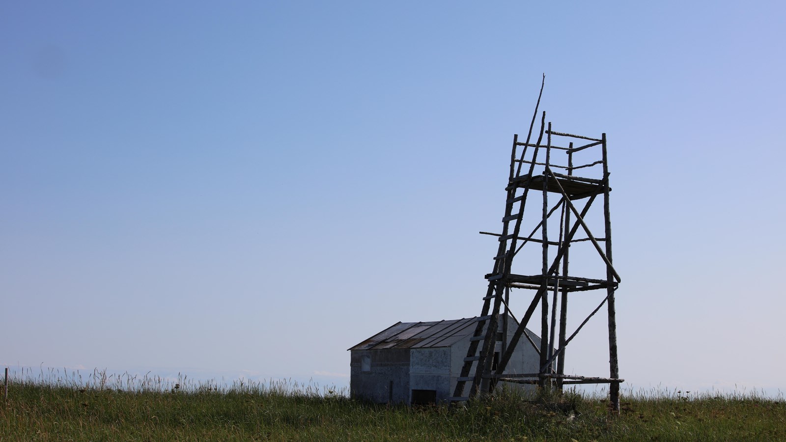 wooden structure on hill in the tundra