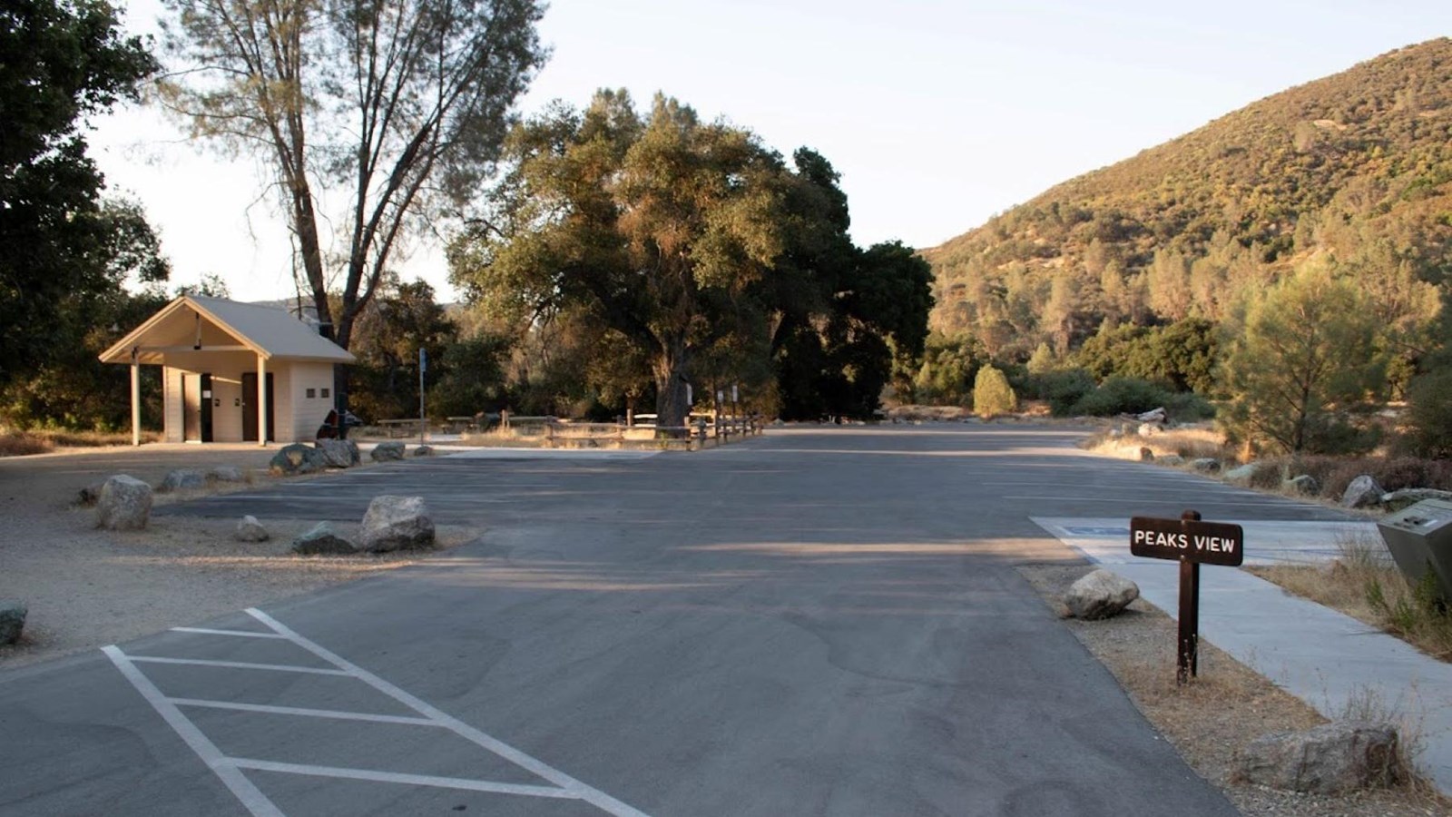 Paved parking area located near a seasonal stream in a rolling landscape of Oaks and Grey Pines