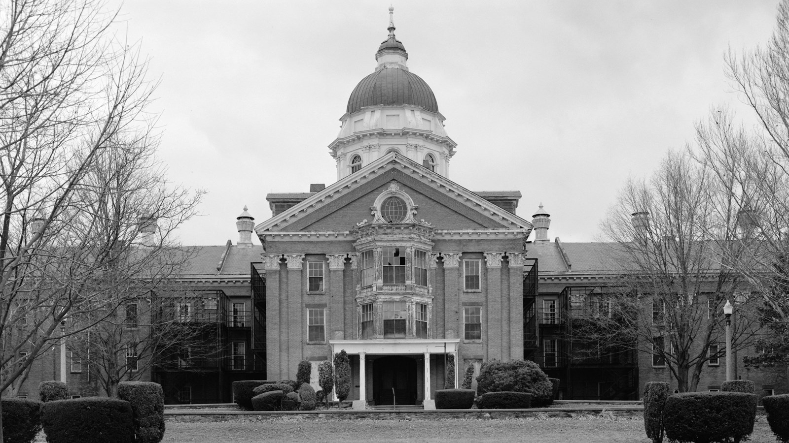 Black and white photo of a stately building with a dome on the roof