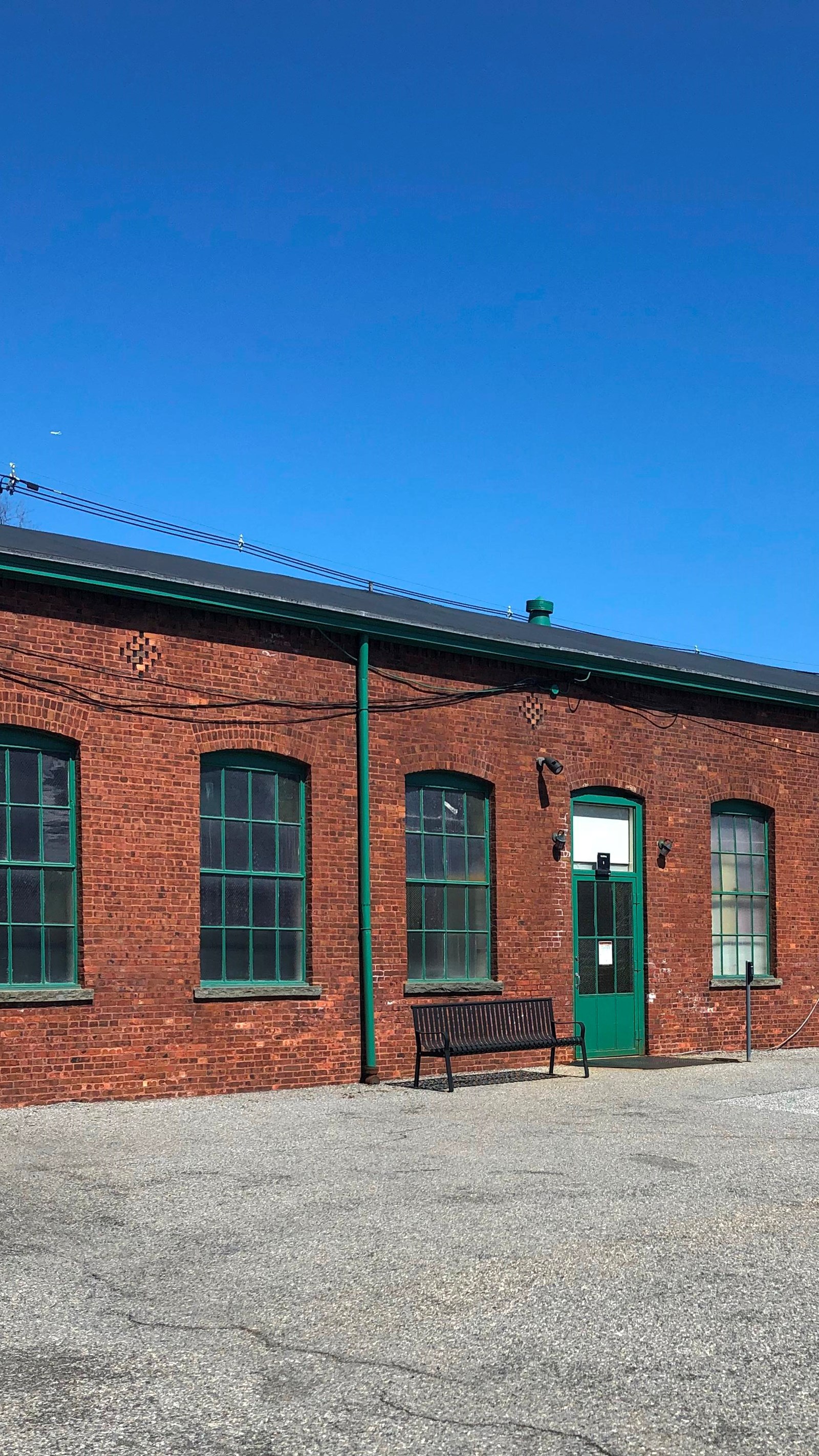 Long rectangular one story red brick building. sky in background